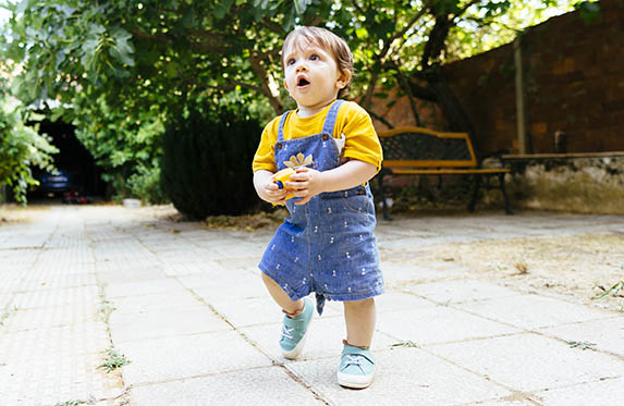 baby taking first steps in the backyard