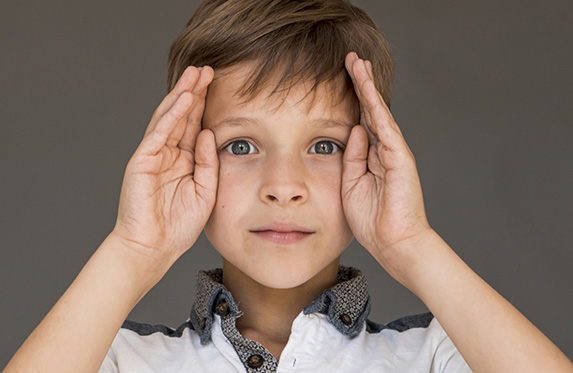 boy with hands on side of eyes