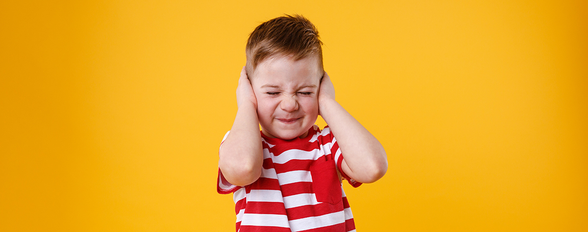 Little boy covering his ears