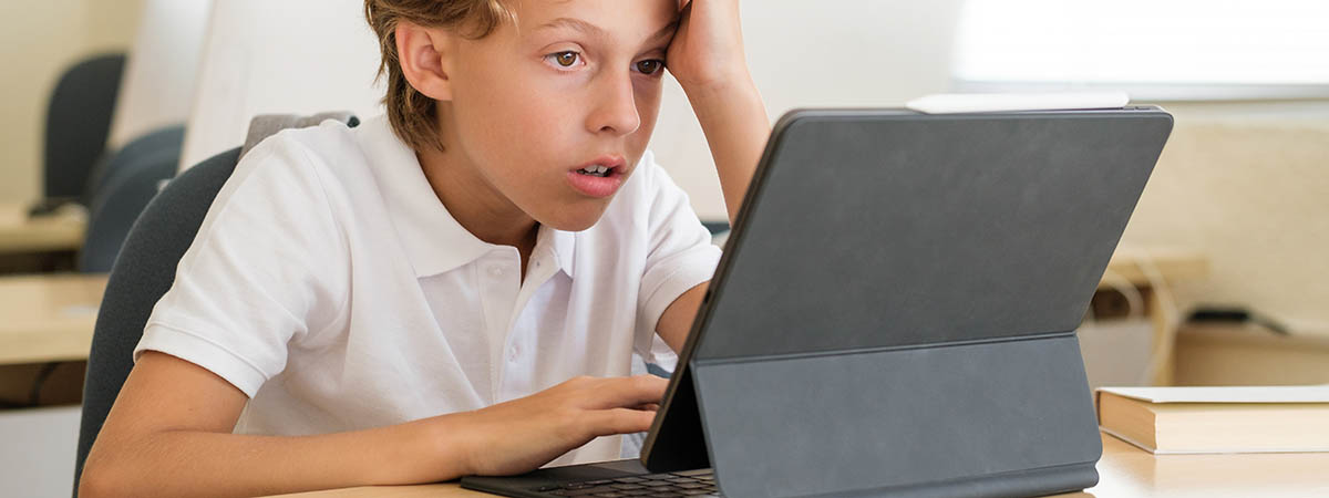 boy frustrated in front of tablet